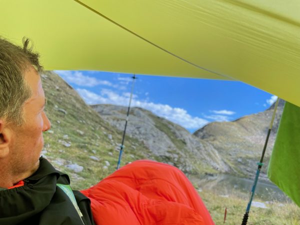 falko krismayr network marketing professional sitting under a tend in the mountains.