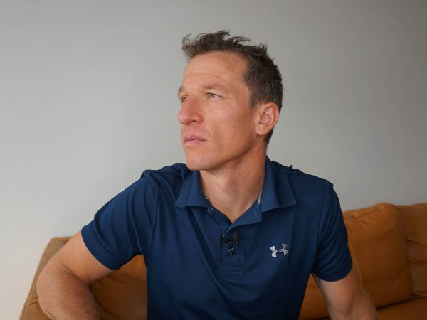 falko krismayr network marketing expert sitting on a couch in a living room.