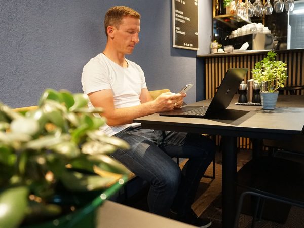 falko krismayr network marketing expert sitting at a table with a laptop.