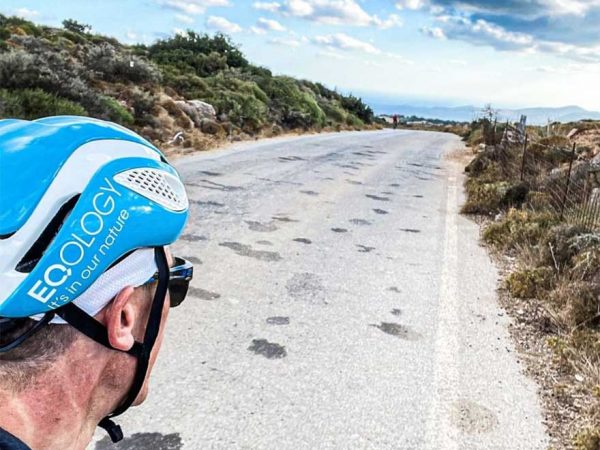 falko krismayr network marketing expert riding a bike down a road next to a forest.