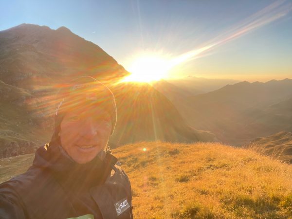 falko krismayr network marketing professional standing on top of a lush green hillside.